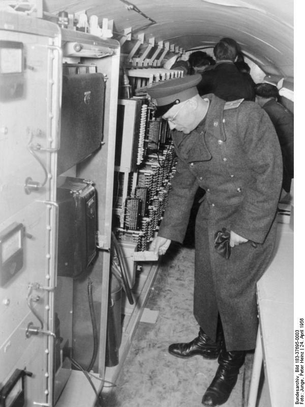 An officer of the Soviet armed forces in Germany draws attention to the English labelling of the facility in the tunnel